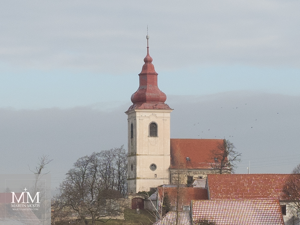 Barokní kostel, hejno ptáků. Fotografie vytvořena objektivem Olympus 12 - 40 mm 2.8 Pro.